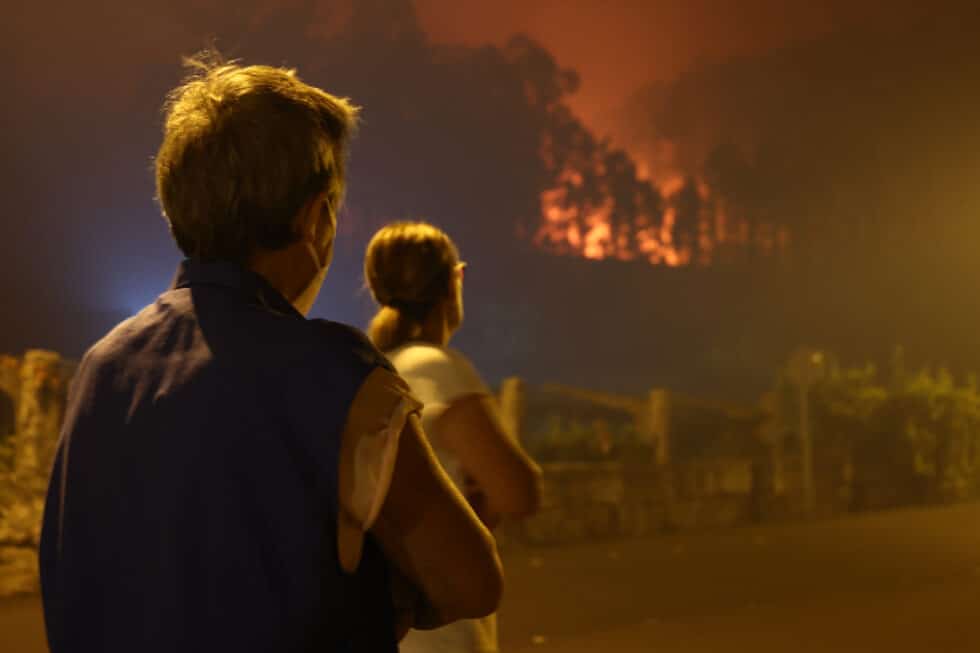 Dos personas observan el avance del Fuego en la localidad de Caldas de Reis, en Pontevedra