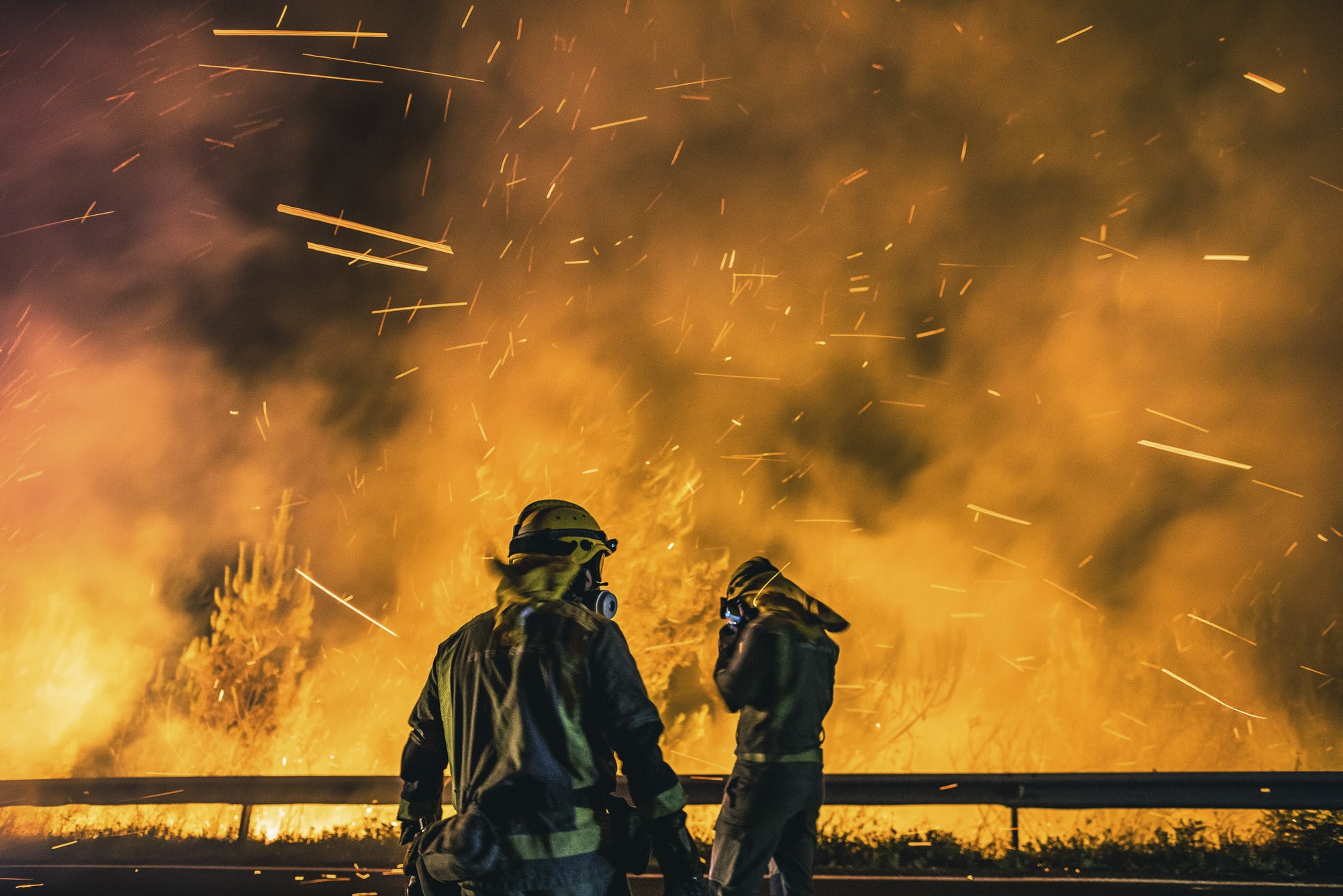 Operarios de las Brigadas de Refuerzo de Incendios Forestales (BRIF) lucha contra las llamas en la madrugada de este sábado para extinguir el incendio declarado en el día anterior en la parroquia de Cures, Boiro, A Coruña