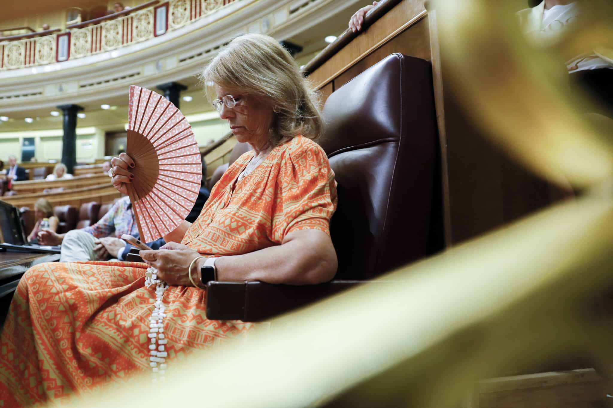 La diputada popular Elvira Rodríguez se abanica por el calor durante la sesión extraordinaria en el Congreso de los Diputados, que debate la convalidación del real decreto-ley sobre las medidas de ahorro energético