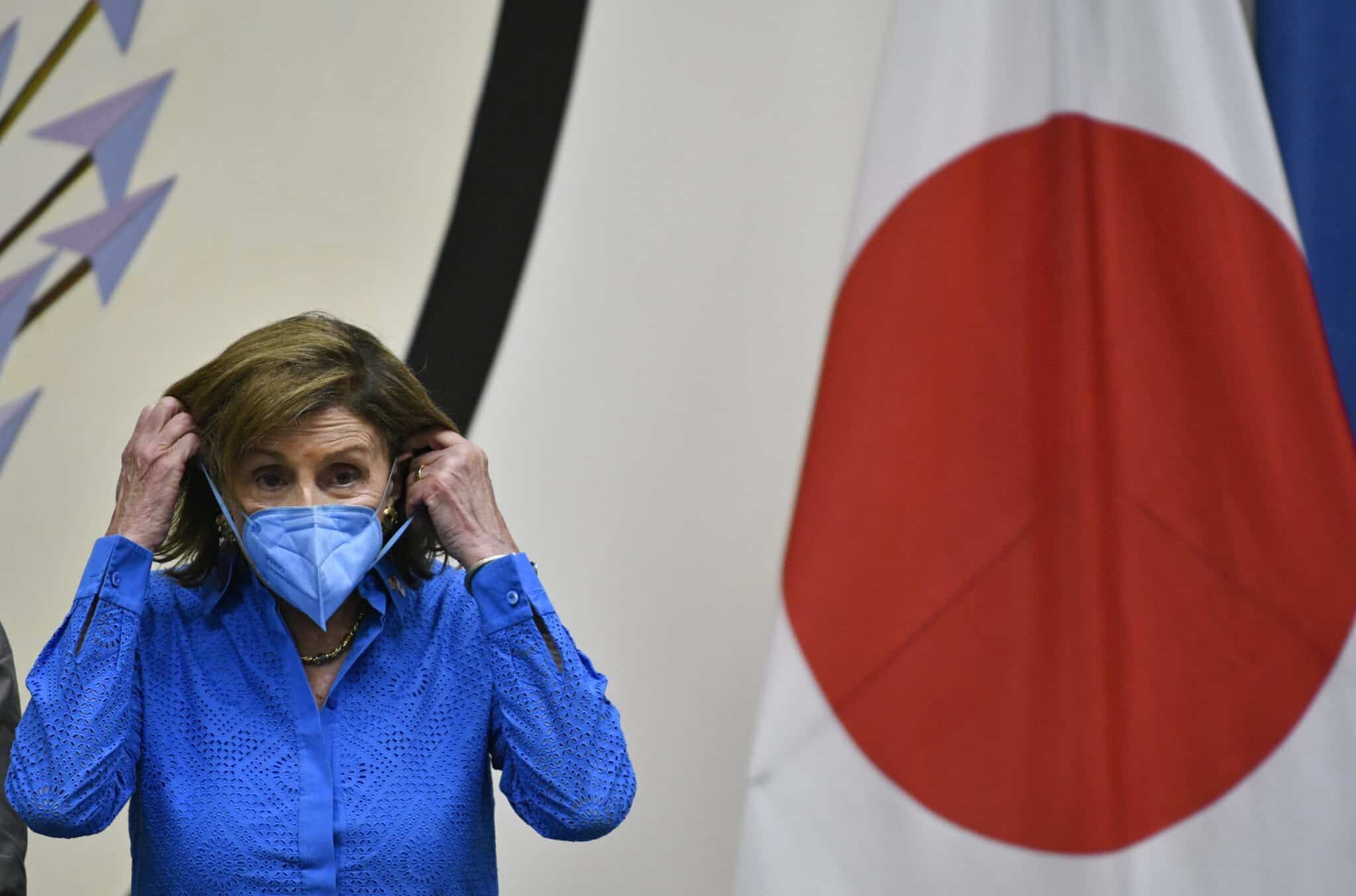 La presidenta de la Cámara de Representantes de EE.UU., Nancy Pelosi, se pone la mascarilla durante una rueda de prensa en la Embajada de EE.UU. en Tokio (Japón)