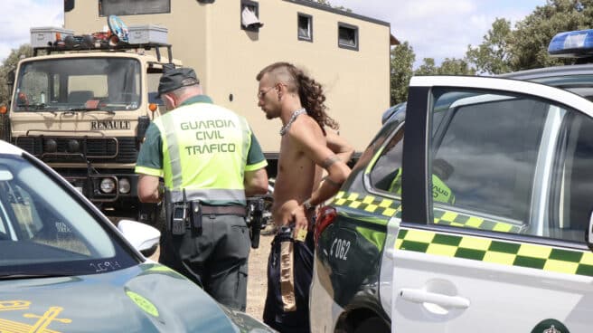 Un agente de la Guardia Civil habla con un asistente a la fiesta "rave" que se celebra desde el pasado viernes a orillas del embalse zamorano de Almendra