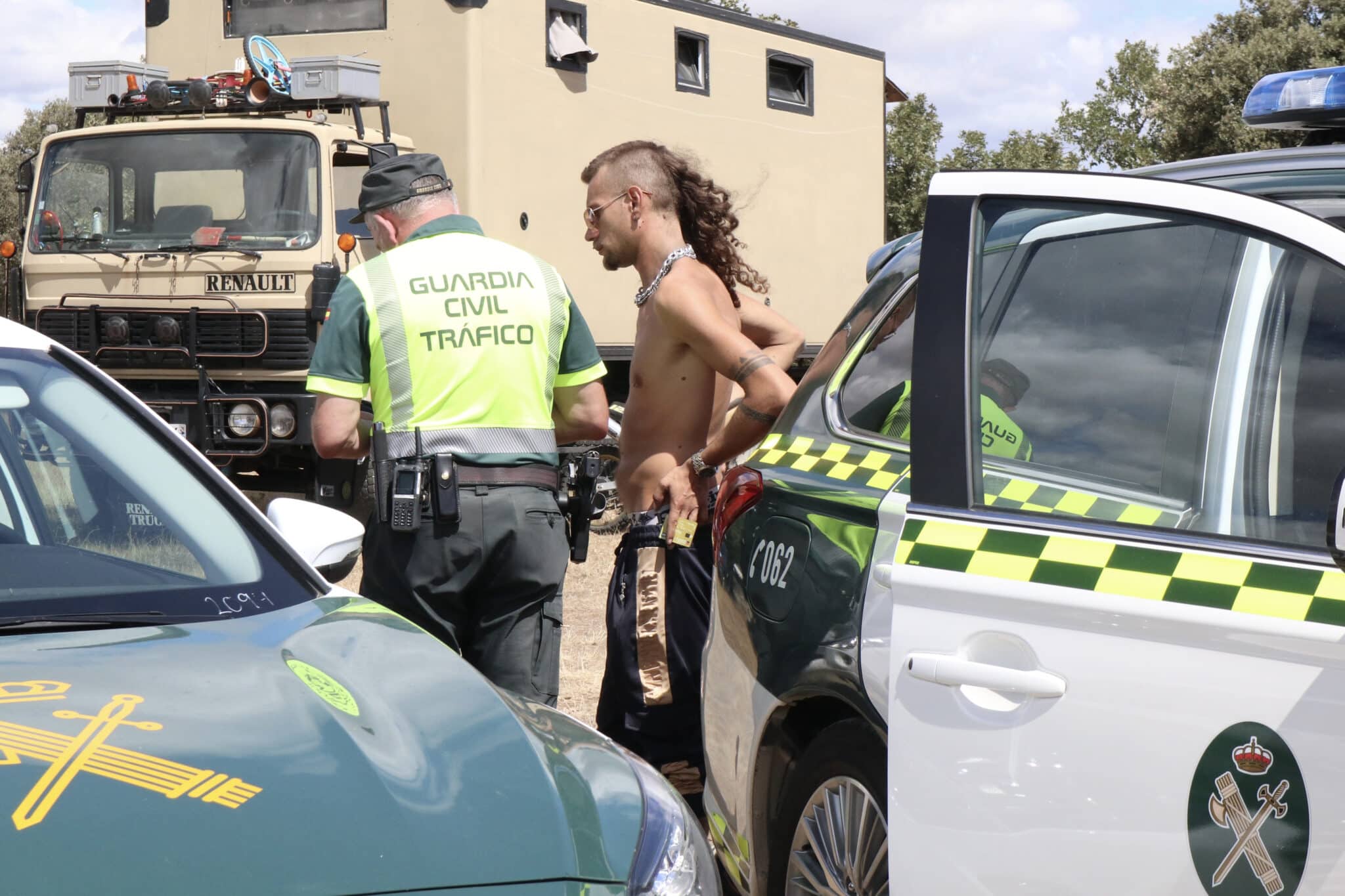 Un agente de la Guardia Civil habla con un asistente a la fiesta "rave" que se celebra desde el pasado viernes a orillas del embalse zamorano de Almendra