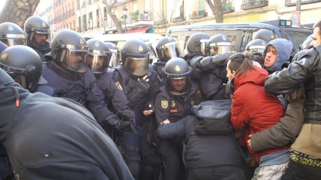 Tensión entre antidisturbios de la Policía Nacional y activistas de la plataforma 'Stop Desahucios' en una actuación en Madrid.