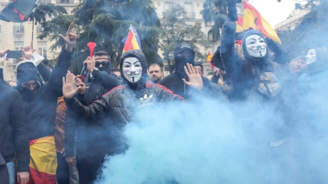 Manifestantes con máscaras de Anonymous y banderas de España, a las puertas del Congreso en marzo de 2020.