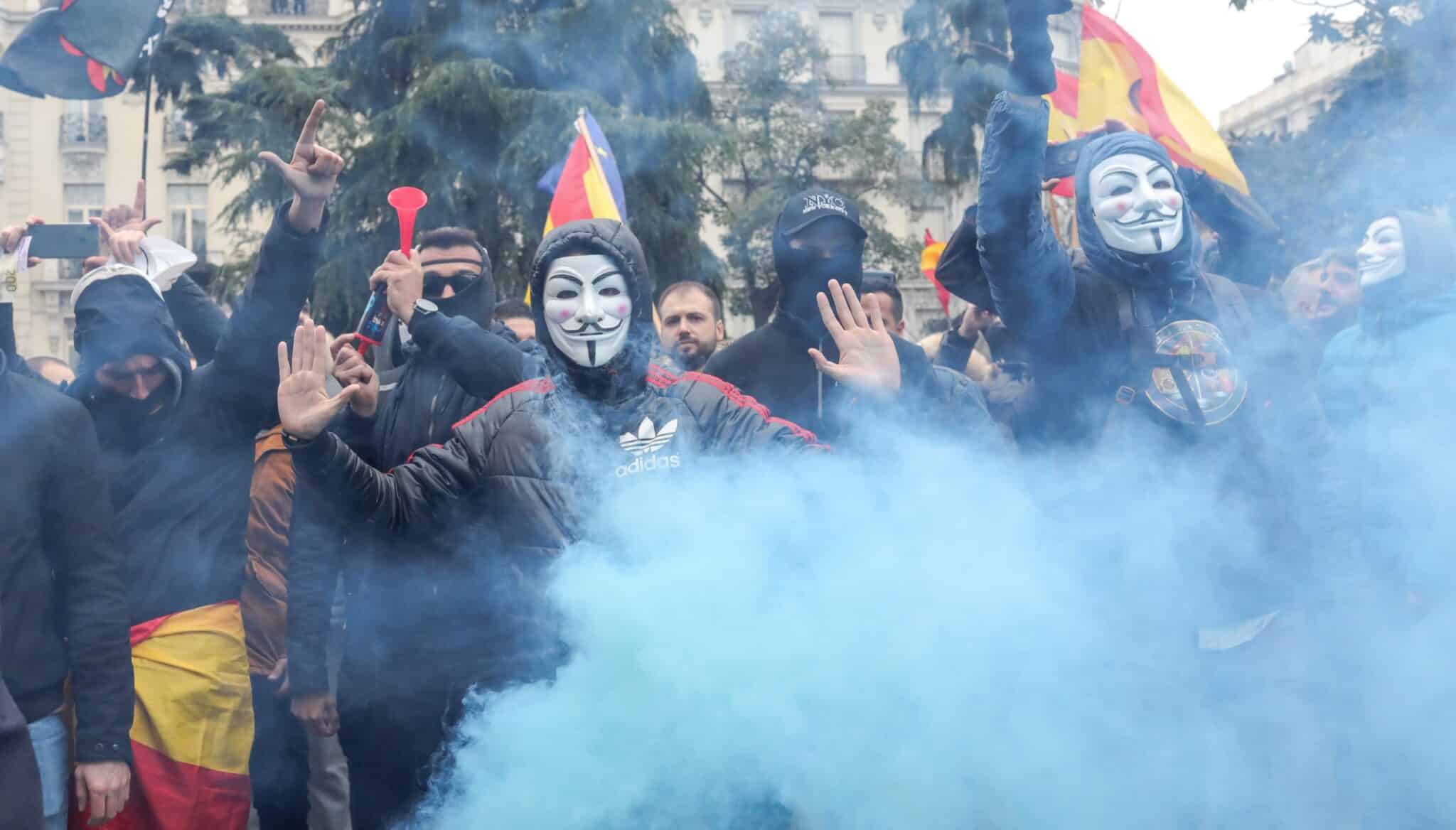 Manifestantes con máscaras de Anonymous y banderas de España, a las puertas del Congreso en marzo de 2020.