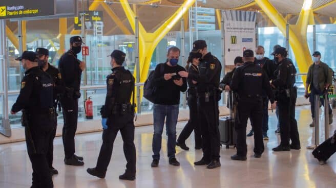Policías nacionales, en un control a los pasajeros de la T4 del Aeropuerto Adolfo Suárez Madrid-Barajas.