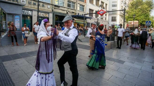 Un par de parejas de chulapos hace una demostración de chotis a pie de calle ante turistas y curiosos en el arranque de las fiestas de agosto de Madrid. ¿Por qué en Madrid ya no se baila el chotis ni por la Virgen de la Paloma? El popular baile madrileño no cuenta con protección oficial y solo unos pocos mantienen una tradición en peligro de extinción.