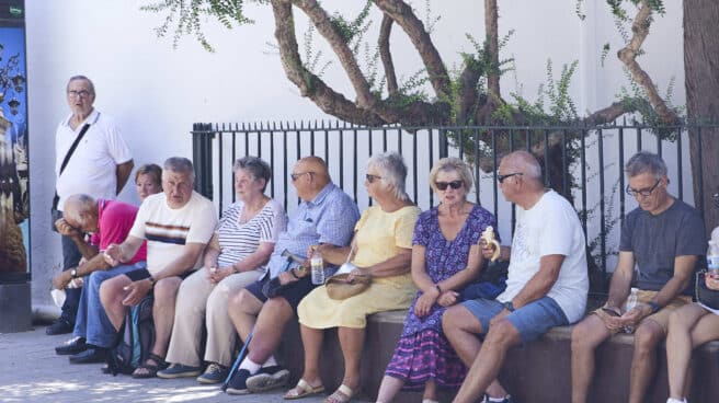 Varias personas mayores se resguardan del calor en Sevilla.