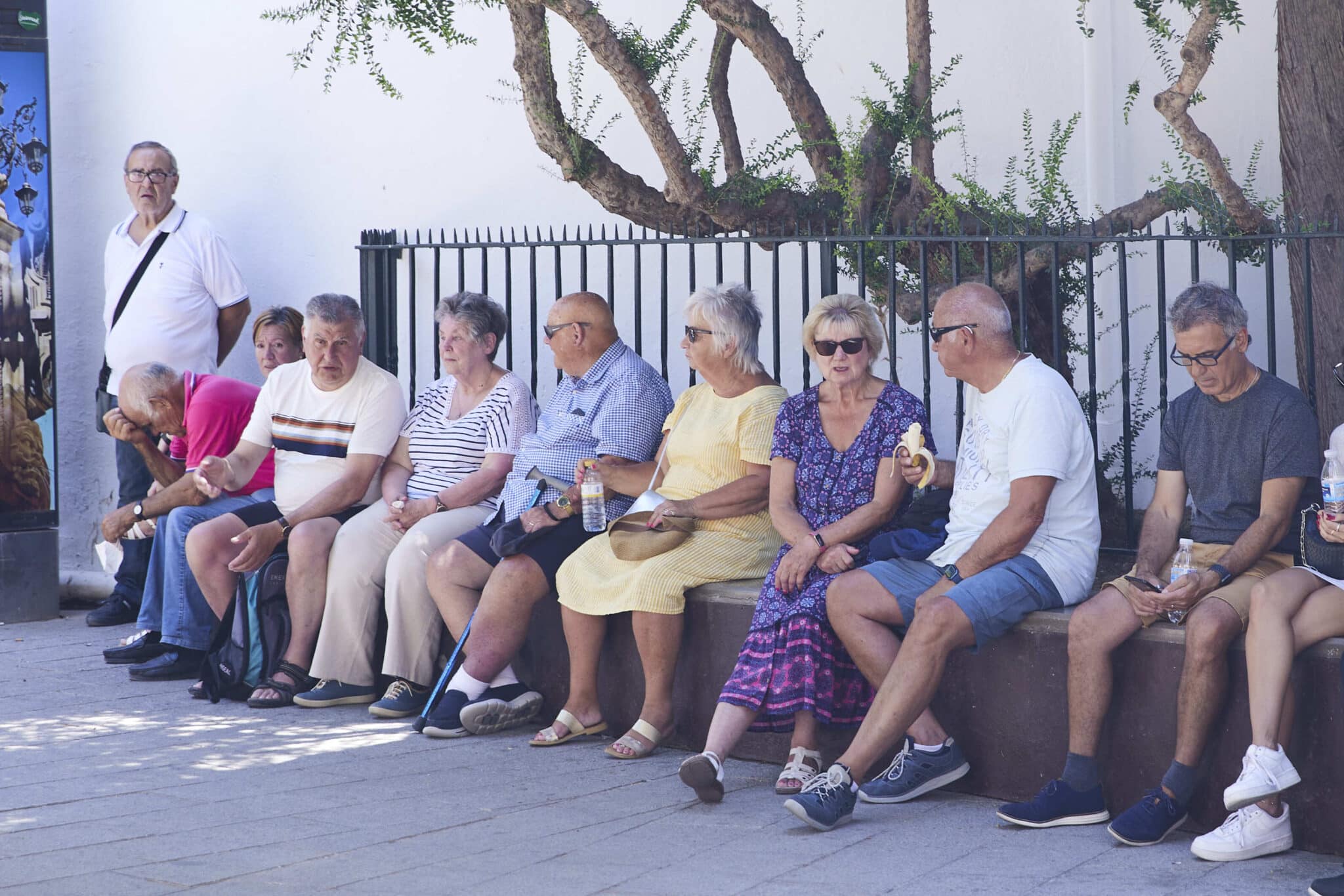 Varias personas mayores se resguardan del calor en Sevilla.