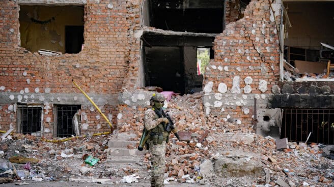 Ucrania, Irpin: Un soldado ucraniano se para con su rifle frente a un edificio destruido.