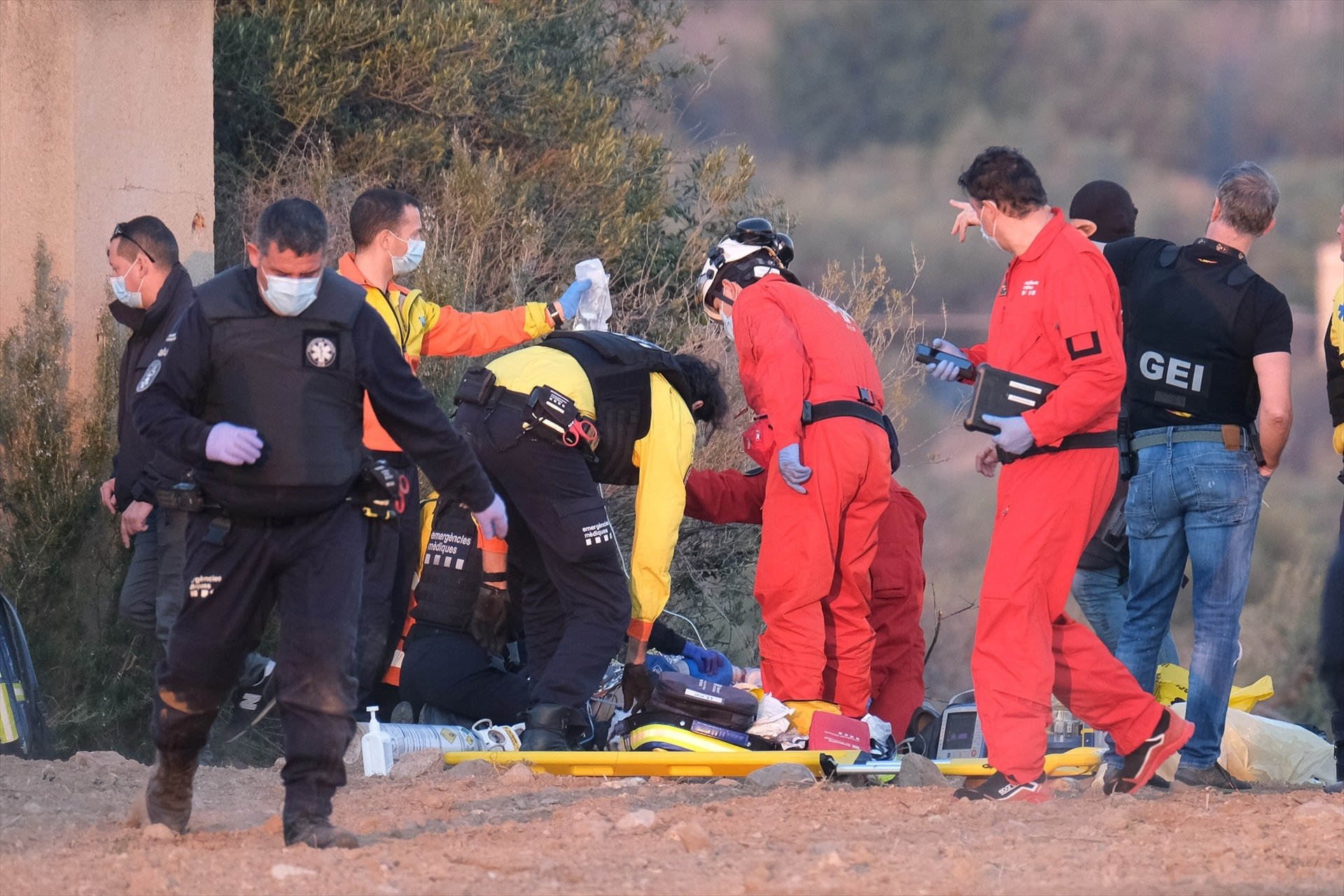 Un grupo de sanitarios asisten a uno de los heridos en el lugar donde estaba detenido el hombre que ha herido con un arma de fuego a tres excompañeros y a un mosso d´esquadra en su huida