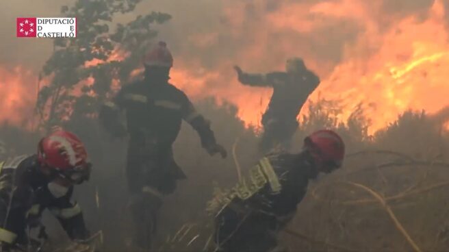 Bomberos corren frente a las llamas en el incendio de Bejís.