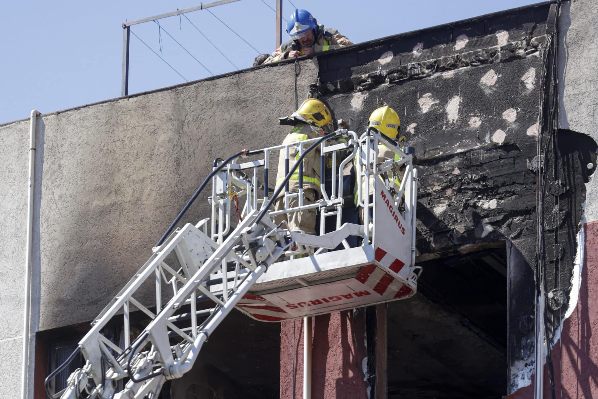 Los bomberos trabajan en el edificio de Badalona donde se ha producido el incendio
