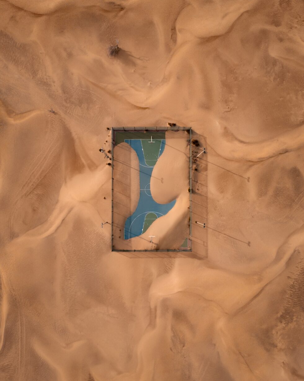 Después de la tormenta una pista de baloncesto tomada por la arena del desierto en Emiratos Árabes Unidos.