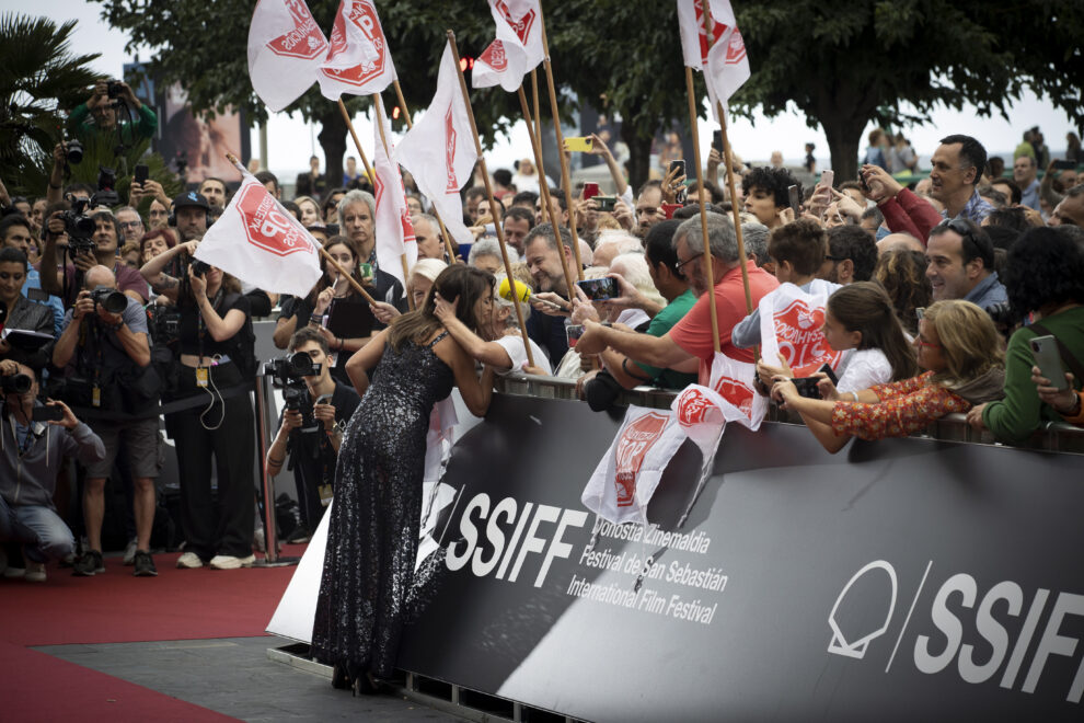 La actriz Penélope Cruz saluda a la portavoz de la plataforma Stop Desahucios, Rosa García, en la alfombra roja del Festival Internacional de Cine de San Sebastián