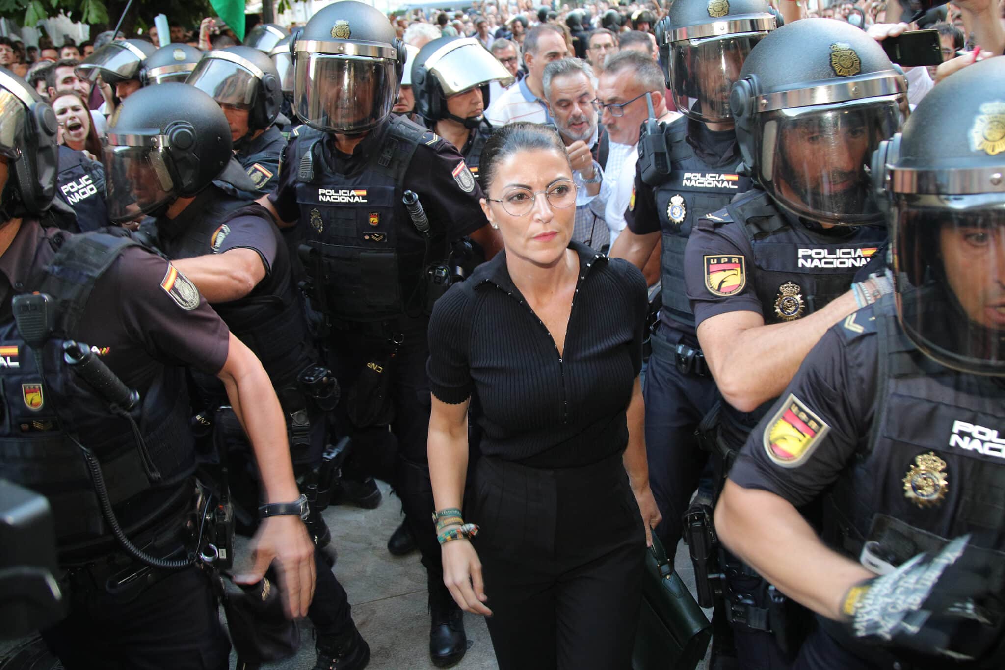 La ex política Macarena Olona (c) intenta acceder a un acto en la facultad de Derecho de Granada este jueves. Varios centenares de personas se han concentrado este jueves en la Facultad de Derecho de Granada para intentar impedir la conferencia de la que fuera candidata de Vox a la Junta, Macarena Olona, esta tarde en la universidad.