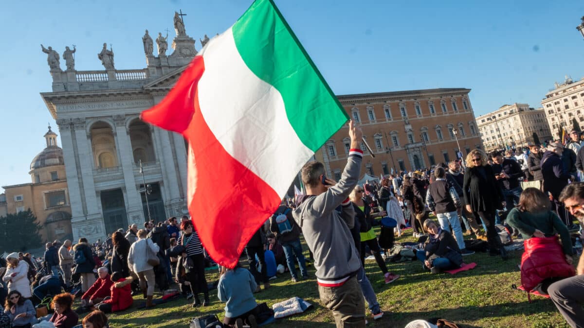 Un hombre porta una bandera italiana en Roma