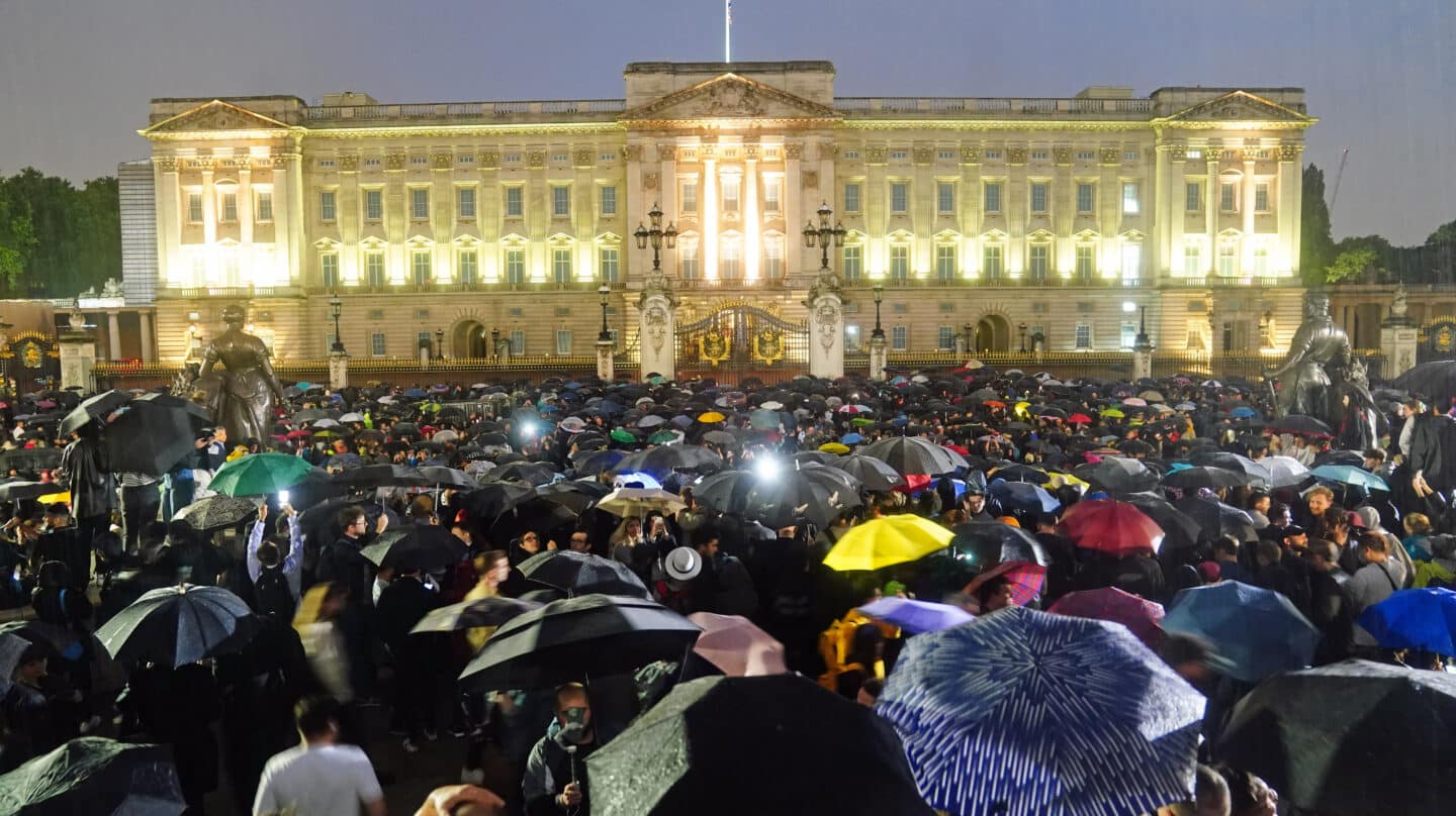 La multitud se concentra, de noche y bajo la lluvia, a las puertas del Palacio de Buckingham tras la muerte de Isabel II de Inglaterra