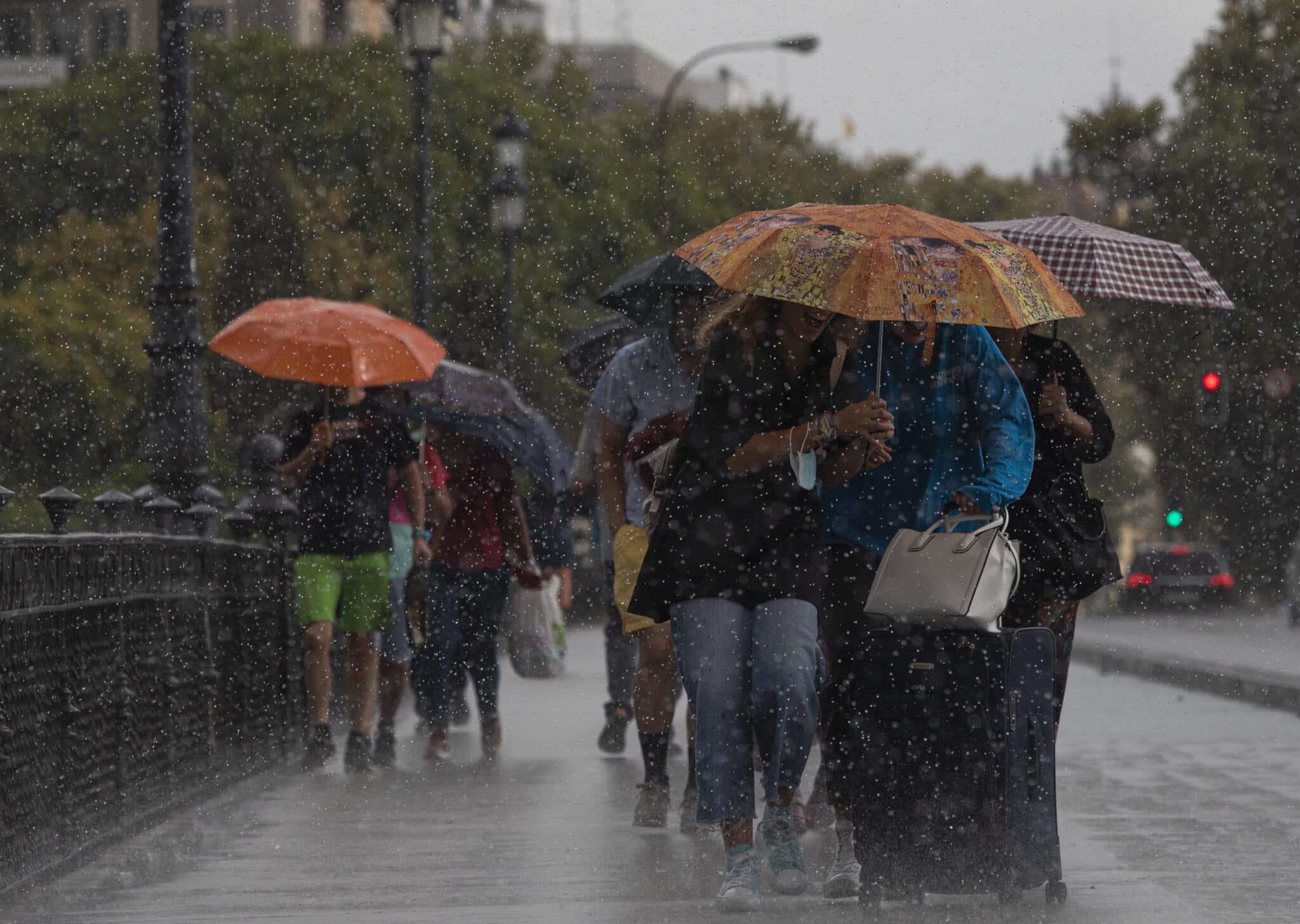 Varias personas caminan bajo sus paraguas el día en que han puesto en aviso amarillo a la Comunidad de Andalucía por tormentas y lluvias.