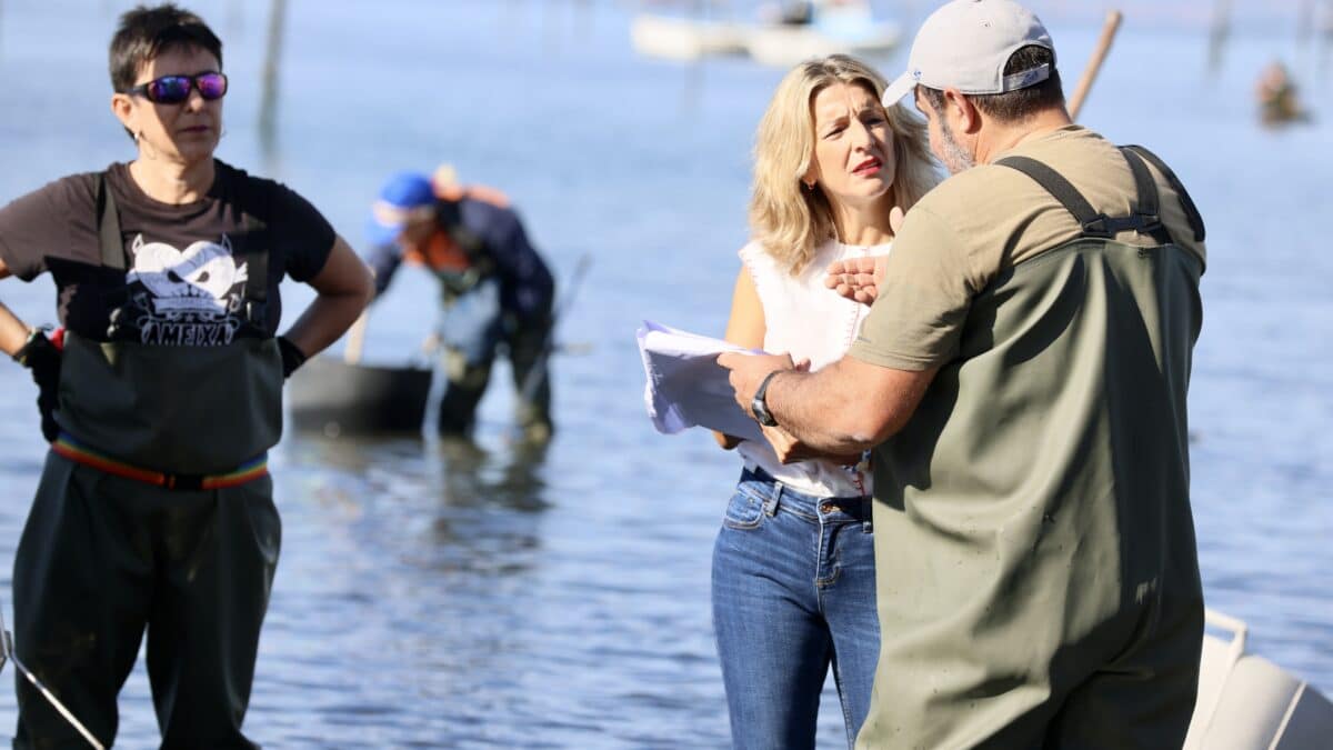 La vicepresidenta segunda del Gobierno y ministra de Trabajo, Yolanda Díaz habla con un mariscador en Vilagarcía de Arousa