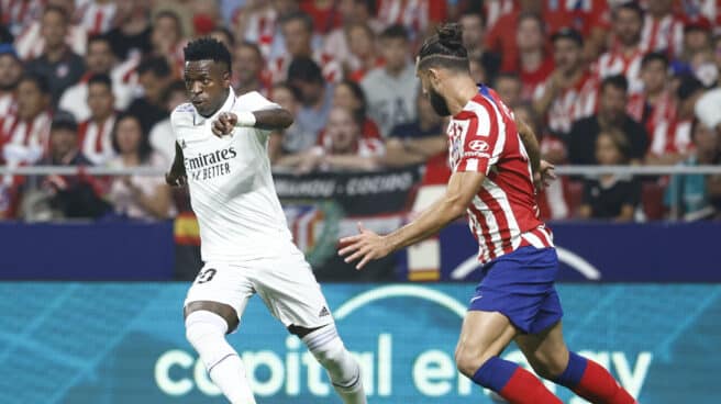 El delantero brasileño del Real Madrid, Vinicius Jr. (i), con el balón ante el defensa brasileño del Atlético de Madrid, Felipe Monteiro, durante el encuentro correspondiente a la sexta jornada de primera división