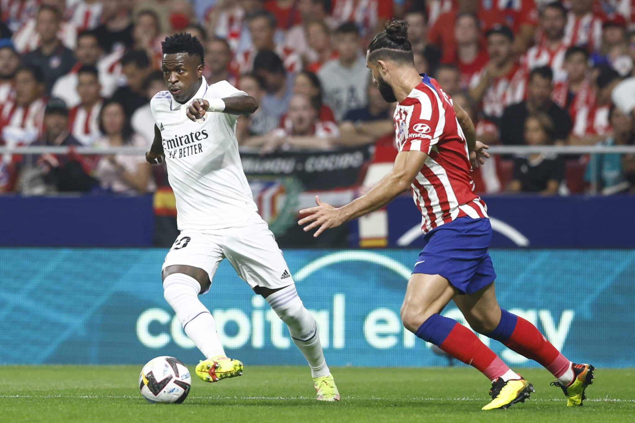 El delantero brasileño del Real Madrid, Vinicius Jr. (i), con el balón ante el defensa brasileño del Atlético de Madrid, Felipe Monteiro, durante el encuentro correspondiente a la sexta jornada de primera división