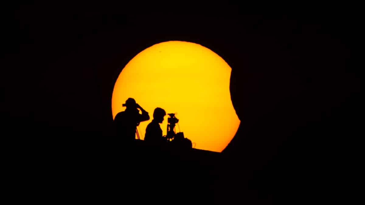 Profesionales ven el eclipse parcial solar en Chennai (India).