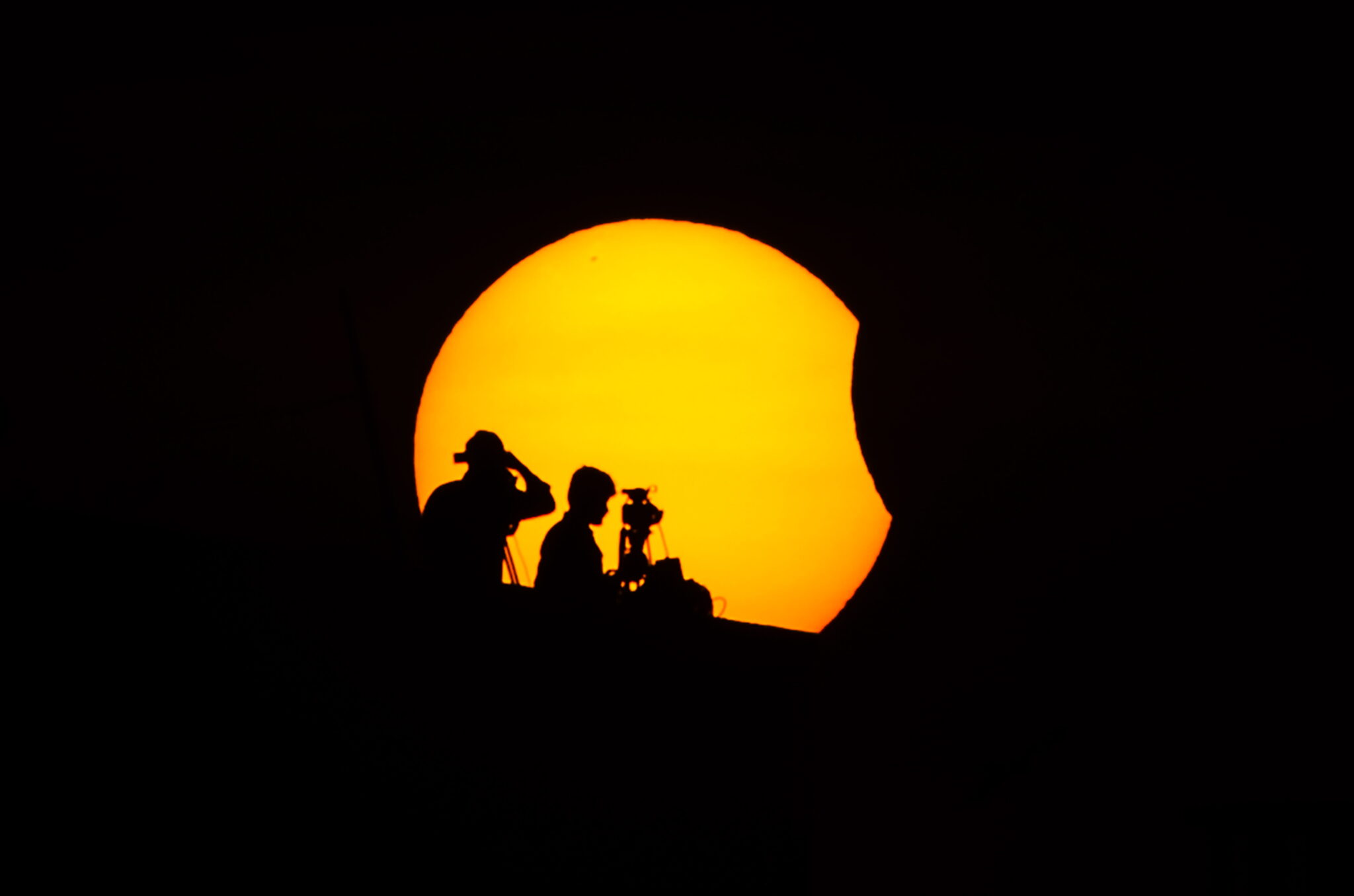 Profesionales ven el eclipse parcial solar en Chennai (India).