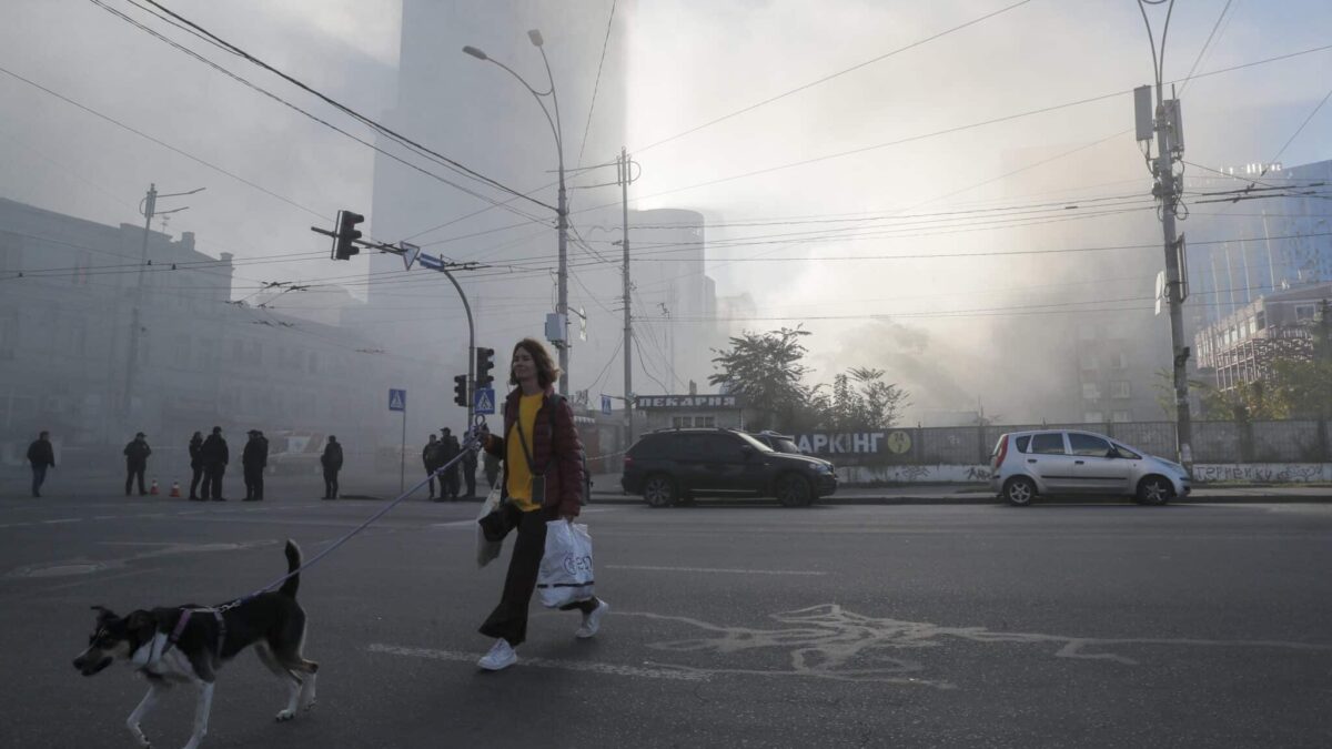 Una mujer pasea a su perro tras el bombardeo en Kiev (Ucrania).