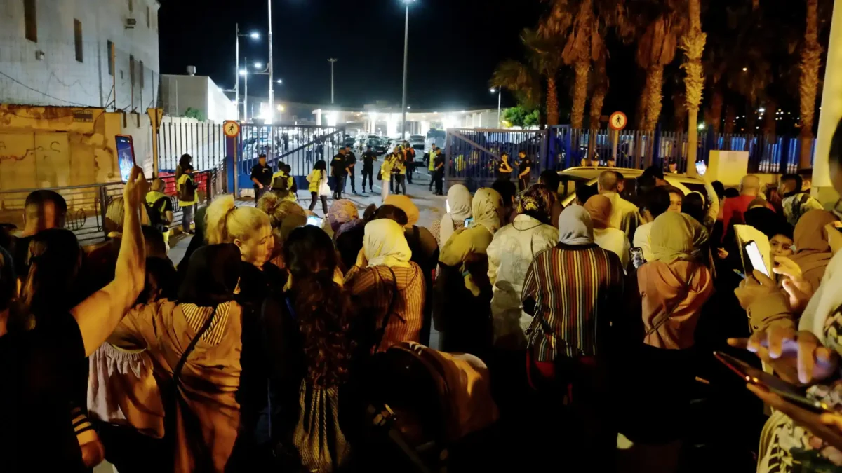 Un grupo de personas espera a allegados que cruzan la frontera en Melilla
