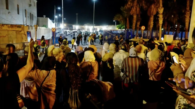 Un grupo de personas espera a allegados que cruzan la frontera en Melilla Un grupo de personas espera a allegados que cruzan la frontera en Melilla