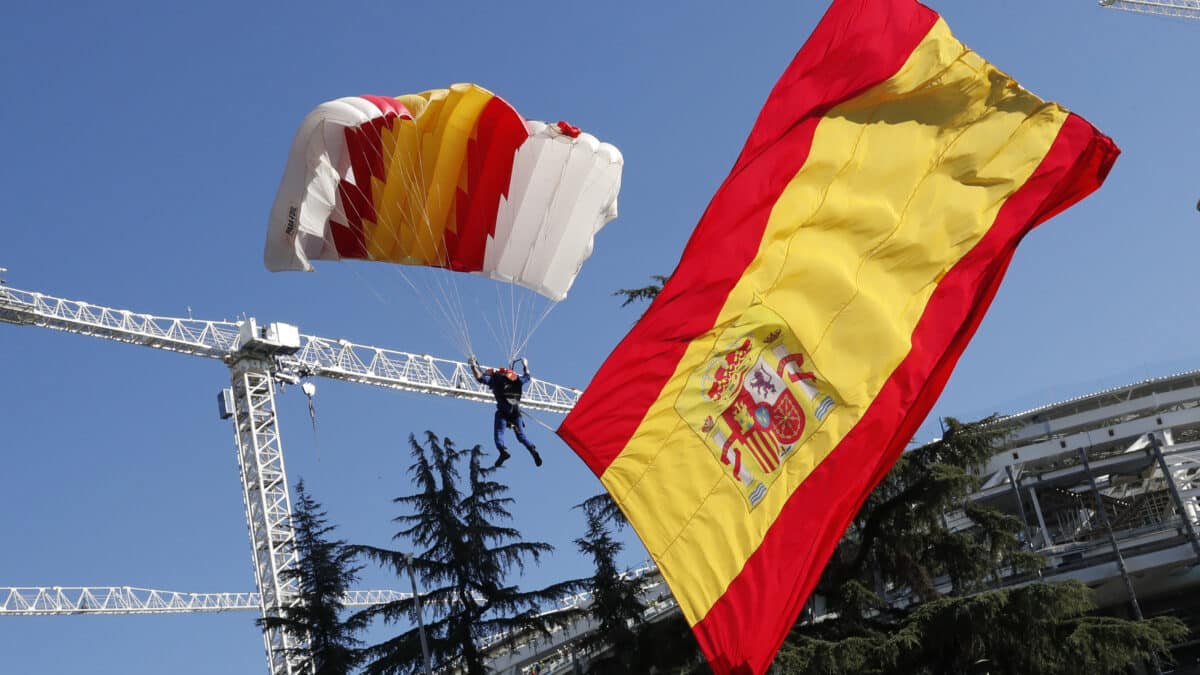 El soldado de la patrulla acrobática de paracaidismo del Ejército del Aire Óscar García García realiza un salto con la bandera de España desplegada al inicio del desfile del Día de la Fiesta Nacional, este miércoles, en Madrid.