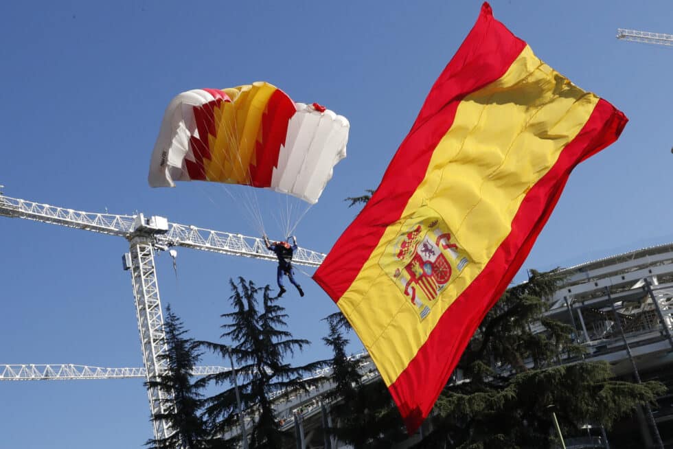 El soldado de la patrulla acrobática de paracaidismo del Ejército del Aire Óscar García García realiza un salto con la bandera de España desplegada al inicio del desfile del Día de la Fiesta Nacional, este miércoles, en Madrid.