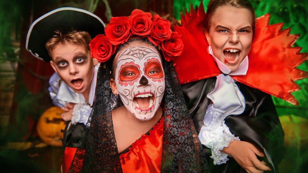 Niños con disfraces de Halloween: fantasma, catrina y un vampiro