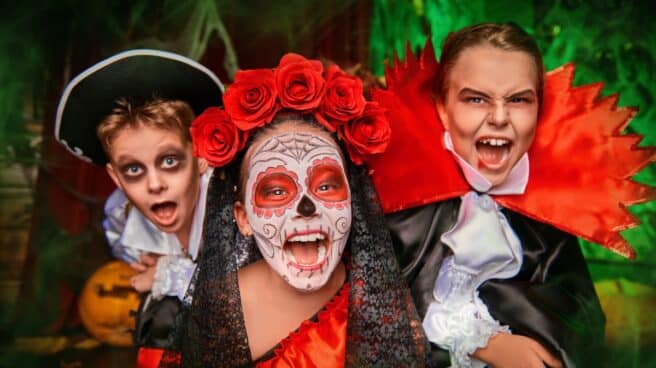 Niños con disfraces de Halloween: fantasma, catrina y un vampiro