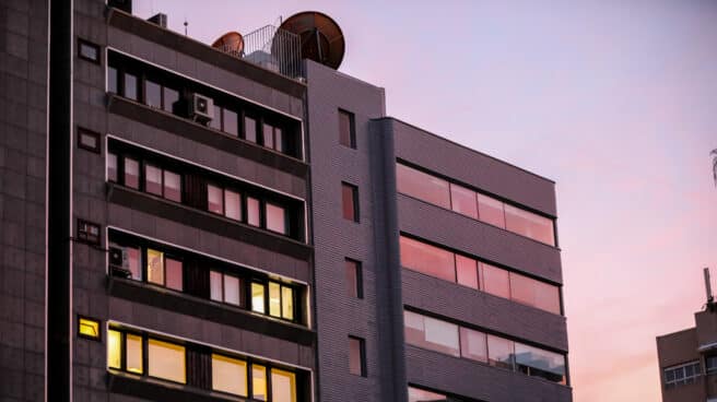 Un edificio con luces encendidas, que consumen una cuarta parte de electricidad Un edificio de casas con las luces encendidas