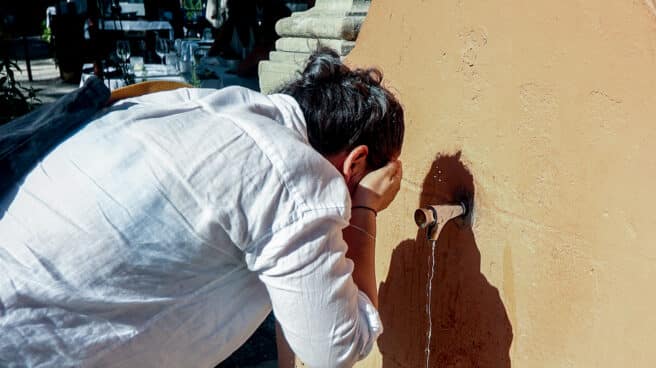 Un hombre se refresca a las puertas de noviembre, que será inusualmente cálido y seco Un hombre se refresca en una fuente de Madrid
