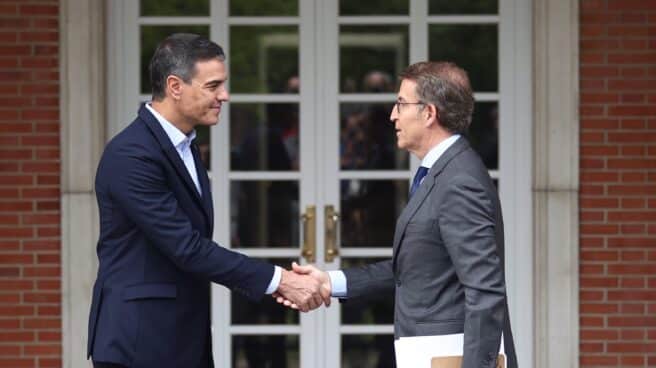 El presidente del Gobierno, Pedro Sánchez (i) y el presidente del Partido Popular, Alberto Núñez Feijóo (d), se saludan a su llegada a una reunión en La Moncloa