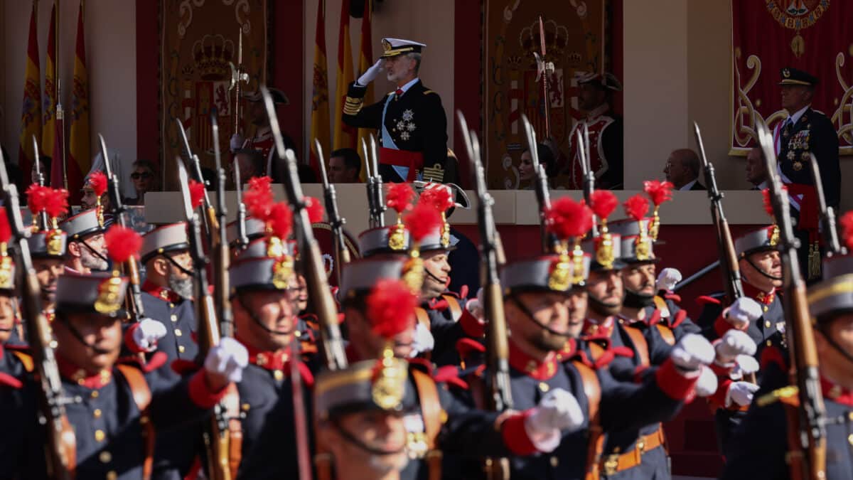 El Rey Felipe VI mientras desfila la Guardia Real durante el acto solemne de homenaje a la bandera nacional y desfile militar en el Día de la Hispanidad