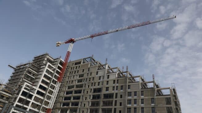 Hasta 280.000 trabajadores de la construcción pasarán a ser fijos por la reforma laboral Imagen de archivo de una grúa en un edificio en obras, en Madrid.