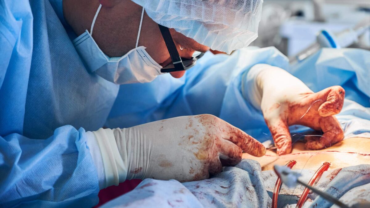Un doctor practica una cirugía estética abdominal.