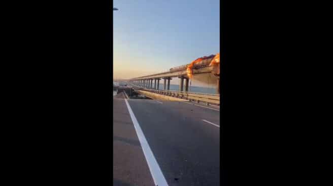 Carretera destruida y tren en llamas en el puente sobre el estrecho de Kerch. Carretera destruida y tren en llamas en el puente sobre el estrecho de Kerch.