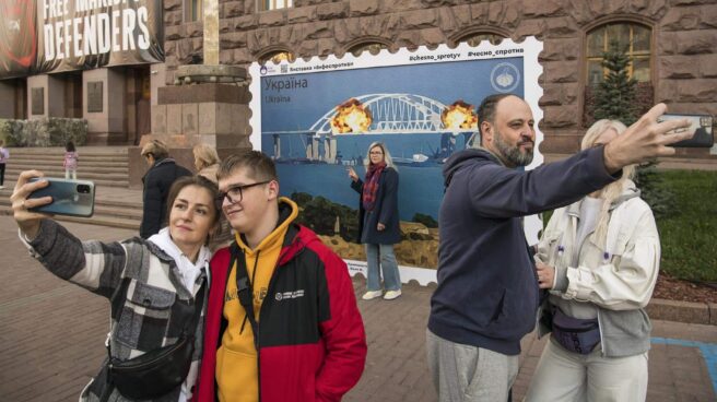 Ciudadanos se hacen fotos frente a un sello que simula las explosiones del puente de Crimea, en Kiev.