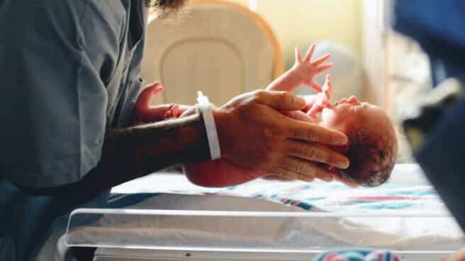 recien_nacido_derecho_hospital_madre una madres coloca a su hijo recién nacido sobre una báscula para pesarle