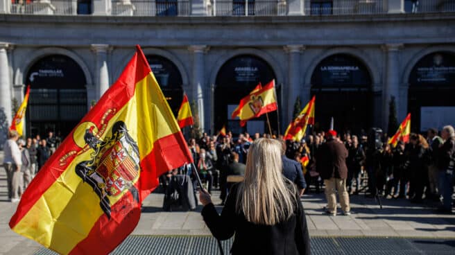 Varias personas, con banderas de España con el águila de San Juan, asisten a un acto organizado por el Movimiento Católico español (MCE) en memoria de Francisco Franco y José Antonio Primo de Rivera, en la Plaza de Oriente, el domingo