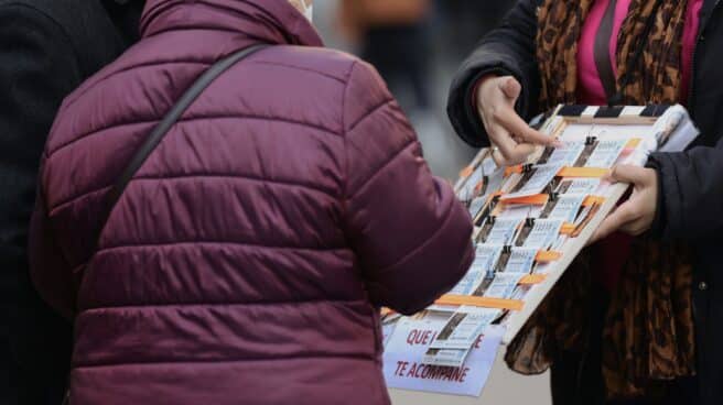 Una mujer compra un décimo de lotería a una vendedora ambulante, tres días antes del Sorteo de La Lotería del Niño