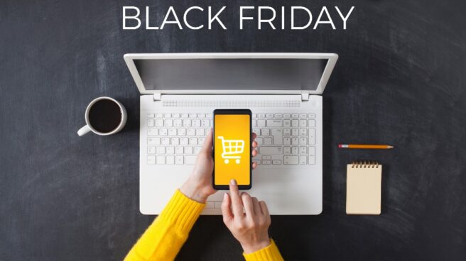 Ordenador portátil en el que se ven ofertas de Black Friday y un smartphone con un carrito de la compra en la pantalla