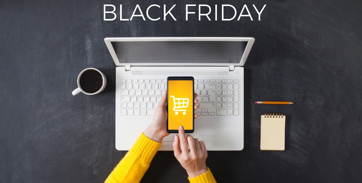 Ordenador portátil en el que se ven ofertas de Black Friday y un smartphone con un carrito de la compra en la pantalla