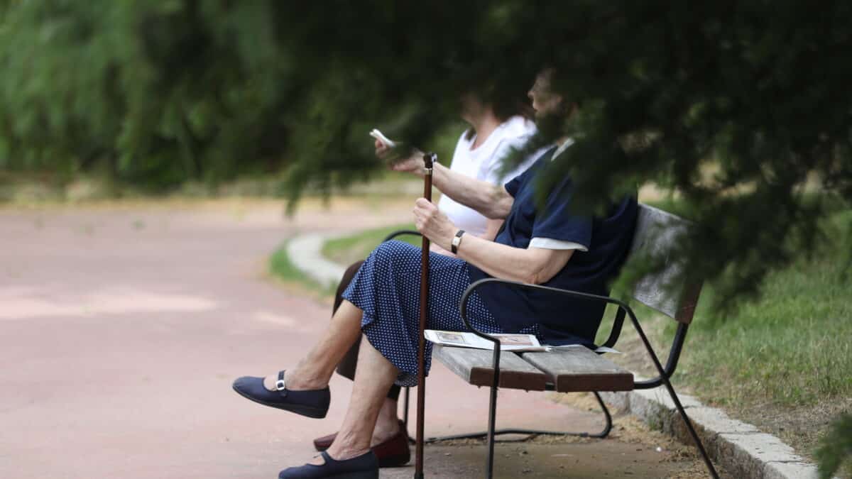 Dos mujeres de edad, sentadas en un banco en Madrid.