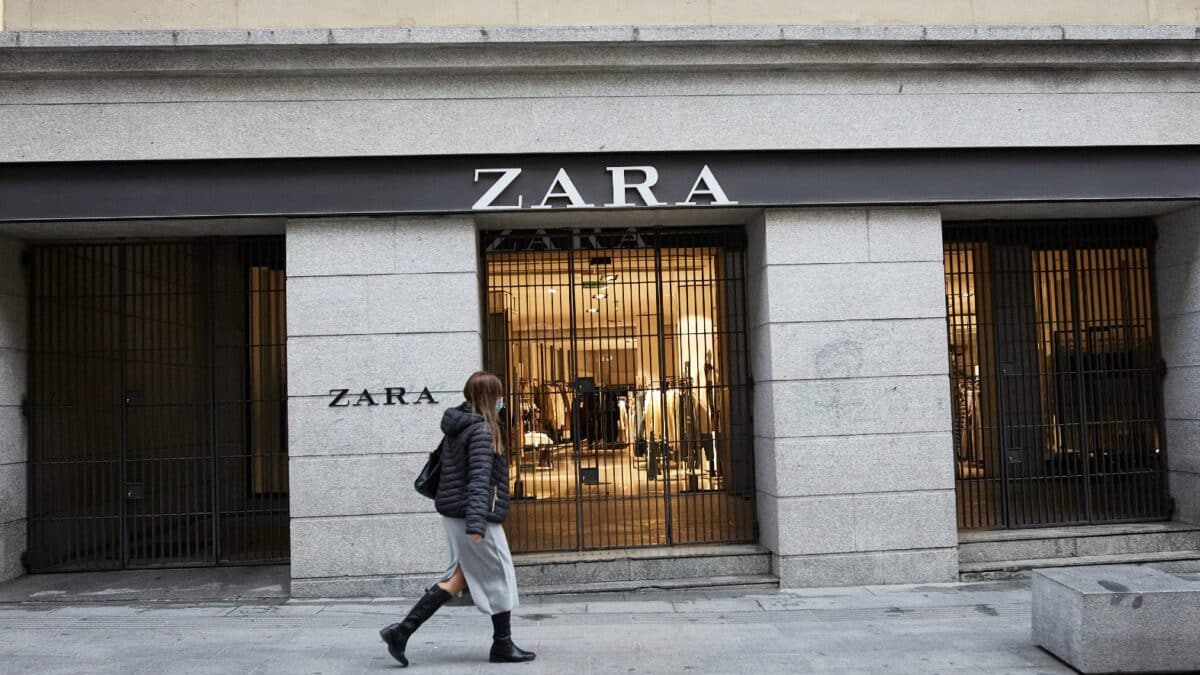 Tienda Zara en Madrid, la primera de la capital, en calle Carretas, al lado de la Puerta del Sol. Una mujer pasa en frente de la tienda paseando.